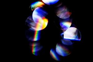 lens gloed, bokeh lichten. reflecties van glas, diamant, kristal. onscherp schijnend kleurrijk regenboog licht lekken, stralen Aan zwart achtergrond foto