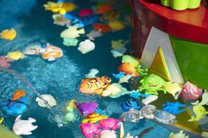 speelgoed- plastic vis in blauw water.speelgoed visvangst foto