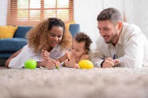 ouders en kinderen kom tot rust in de leven kamer van de huis. kijk maar baby verf Aan de papier gelukkig. foto