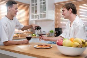 lgbt jong paar vieren de dag van liefde tussen elk andere met prima wijn in de keuken van de huis foto