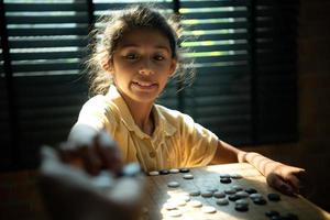 portret van een weinig meisje in kantoor kamer van huis met een spel van Gaan wezen geleerd naar bouwen concentratie en intelligentie. foto