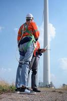 landmeter en ingenieur onderzoeken de rendement van gigantisch wind turbines dat transformeren wind energie in elektrisch energie dat is vervolgens gebruikt in dagelijks leven. foto