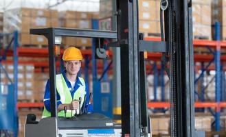 arbeider in auto onderdelen magazijn gebruik een heftruck naar werk naar brengen de doos van auto onderdelen in de opslagruimte plank van de magazijn aan het wachten voor levering naar de auto bijeenkomst lijn foto