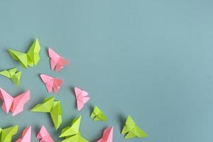 papier vlinders groen en roze kleur vlak leggen Aan een gekleurde achtergrond. lichtheid, voorjaar schoonheid concept foto