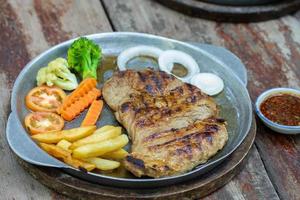 gegrild varkensvlees steaks en Frans Patat met groente foto