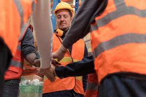 de manager aangemoedigd de magazijn arbeiders naar werk moeilijk naar krijgen de goederen uit van de magazijn naar af hebben de klein kooplieden vanavond. door toetreden handen en creëren een boom foto