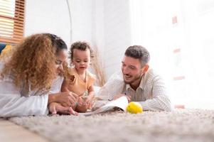 ouders en kinderen kom tot rust in de leven kamer van de huis. kijk maar baby verf Aan de papier gelukkig. foto