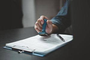 ondertekening goedkeuring Vermelding documenten postzegel bevestiging bezetting handtekening. zakenman hand- stempelen financiën papier werk concept. foto