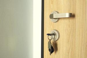 een sleutel met een sleutel fob plakken uit in de deur op slot doen. deur slot detailopname. foto