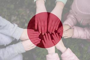 handen van kinderen Aan achtergrond van Japan vlag. Japans patriottisme en eenheid concept. foto