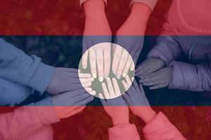 handen van kinderen Aan achtergrond van Laos vlag. lao patriottisme en eenheid concept. foto