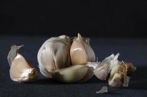 de knoflook, knoflook kruidnagel en huid Aan de donker achtergrond. foto