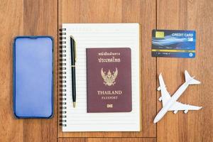vliegtuig met paspoort en mobiele telefoon met notitieblok foto