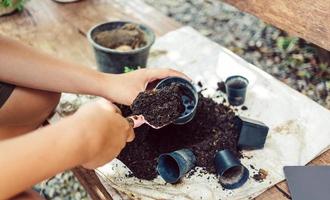 jongen handen scheppen bodem in potten naar bereiden planten voor aanplant vrije tijd activiteiten concept foto