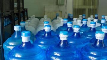 de blauw water gallon met drinken water heeft geweest verzegeld met een plastic zegel in de drinken water fabriek naar wacht voor levering foto