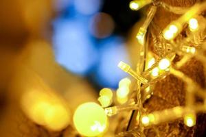 detailopname van Kerstmis lichten en refectie verlichting Aan de boom met kleurrijk wazig en bokeh en zwart achtergrond. foto