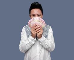 Mens gedekt zijn gezicht met een honderd duizend roepia Indonesisch geld. foto