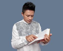 Indonesisch moslim Mens was Holding en lezing al koran foto