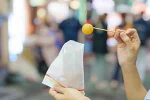 vrouw hand- Holding zoet aardappel bal Bij nacht markt, beroemd Taiwanees straat voedsel van Taiwan. exotisch voedsel in lokaal markt foto