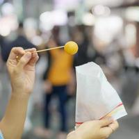 vrouw hand- Holding zoet aardappel bal Bij nacht markt, beroemd Taiwanees straat voedsel van Taiwan. exotisch voedsel in lokaal markt foto