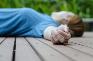 handen van een jong vrouw flauwvallen in de park in de zomer omdat van de heet het weer. foto