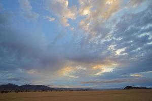 geel en blauw wolken Bij zonsondergang in de namib woestijn foto