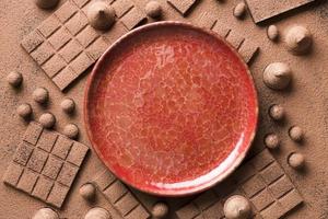 plat assortiment met chocolade en rode keramische plaat foto