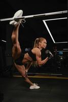 een vrouw met blond haar doet een touw tijdens halter biceps krullen in een sportschool foto