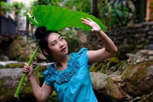 vrouw blokkeert regen met een gigantisch blad foto