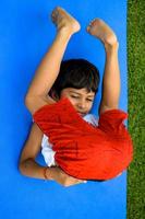 Aziatisch slim kind aan het doen yoga houding in de maatschappij park buitenshuis, kinderen yoga houding. de weinig jongen aan het doen yoga oefening. foto