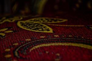 abstract batik met fabriek motieven Aan een rood kleding stof achtergrond foto
