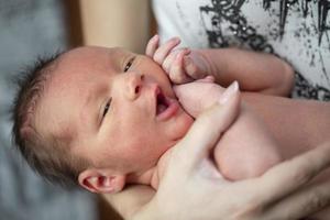 mooi pasgeboren baby in haar armen.de kind is zeven dagen oud. foto