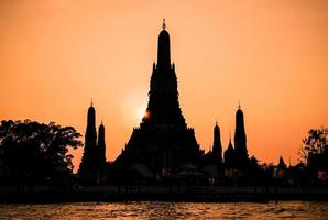 close-up silhouet van wat arun tempel bij zonsondergang in bangkok, thailand foto