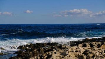 blauw zee Golf en wit schuim en plons. steen strand Aan eiland van Malta, Nee zanderig strand. zomer vakantie grens kader concept. tropisch eiland vakantie achtergrond. toerist reizen banier ontwerp sjabloon. foto