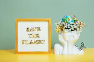 opslaan de planeet tekst met wereld wereldbol in hoofd met bloemen. milieu voor de toekomst, concept van besparing de planeet foto