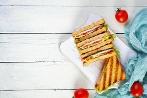 club belegd broodje met ham, tomaat, groen en kaas. gegrild panini. top visie foto