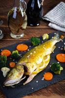 gebakken zee bas vis met groenten en Groenen Aan steen bord foto