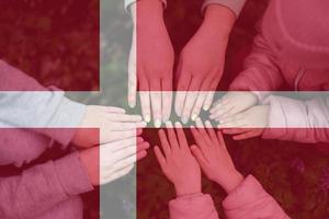 handen van kinderen Aan achtergrond van Denemarken vlag. Deens patriottisme en eenheid concept. foto