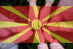 handen van kinderen Aan achtergrond van noorden Macedonië vlag. Macedonisch patriottisme en eenheid concept. foto