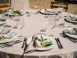 tafel Bij luxe bruiloft ontvangst evenement. mooi bloemen Aan tafel en portie gerechten en bril en decoratie foto