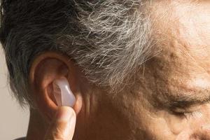 ouder Mens gebruik makend van Op maat gemaakt siliconen oordopjes voor horen bescherming foto