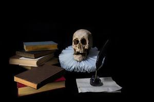boeken met een schacht, inktpot, schedel en kemphaan. wereld literatuur concept foto