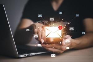 houvast smartphone en laptop met communicatie pictogrammen, brief pictogrammen, e-mail pictogrammen, en nieuwsbrief e-mail en beschermen uw persoonlijk informatie of spam mail, klant onderhoud telefoontje centrum contact ons. foto