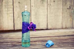 blauw parfum fles Aan de houten achtergrond. afgezwakt afbeelding. foto