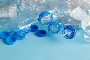 een veel van plastic leeg verkreukelde gebruikt flessen Aan een blauw achtergrond. verspilling en verontreiniging concept foto