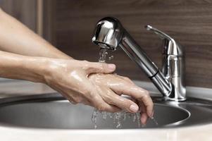 vrouw handen wassen in de gootsteen