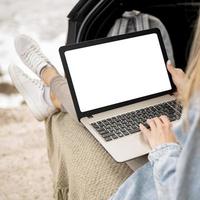 jonge vrouw browsen laptop op road trip foto