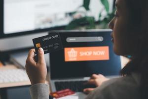 model- credit kaart en gebruik makend van laptop. vrouw houden Visa kaart en werken van huis. online winkelen, e-commerce, internet bankieren, uitgeven geld, werk van huis concept. internet online bank foto