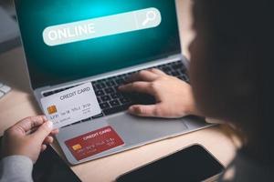 model- credit kaart en gebruik makend van laptop. vrouw houden Visa kaart en werken van huis. online winkelen, e-commerce, internet bankieren, uitgeven geld, werk van huis concept. internet online bank foto