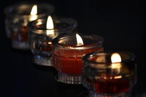 veel ronde glas kaarsen met rood was- foto